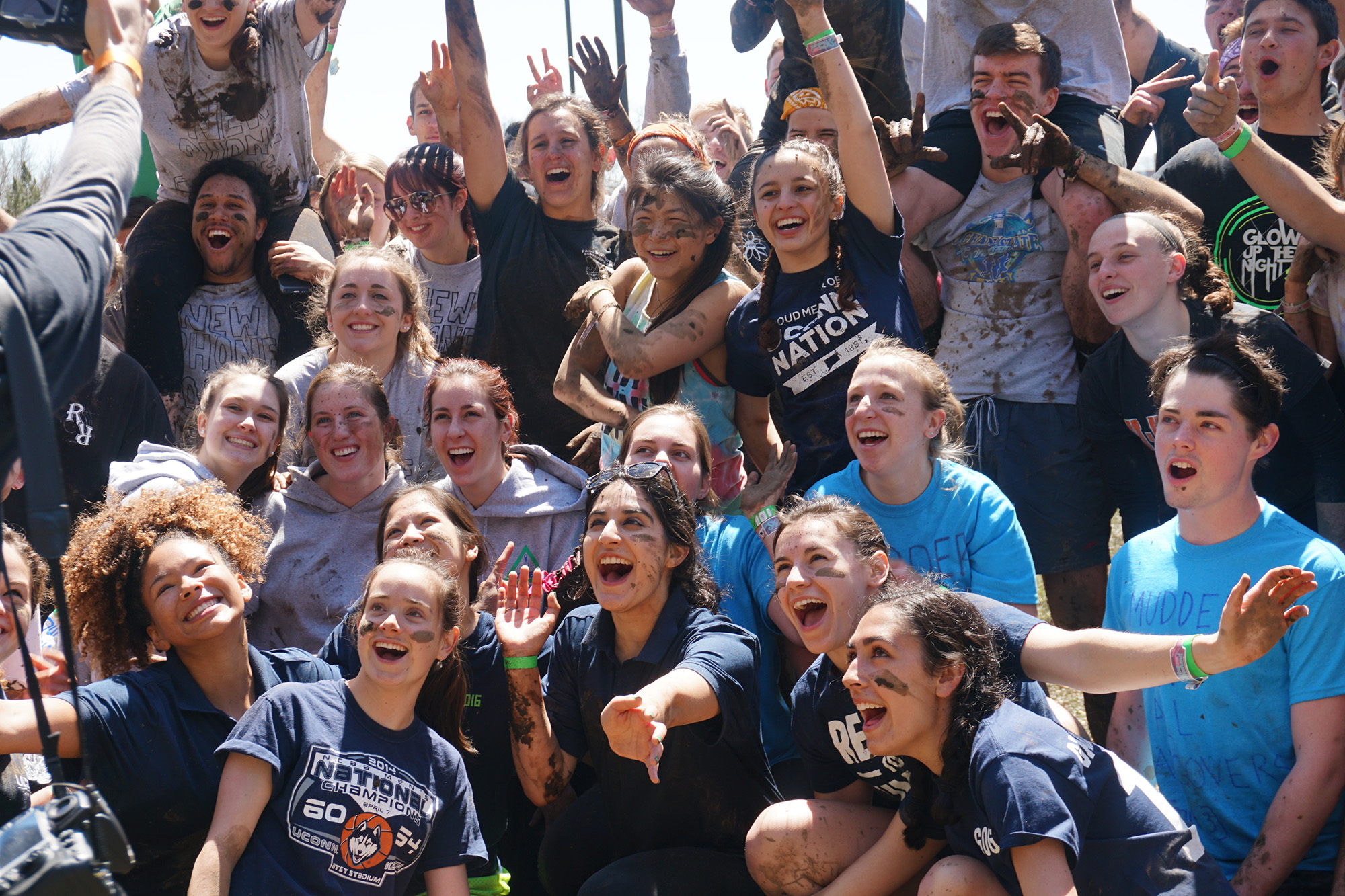 Large group of students laugh and pose during oozeball tournament